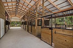 the inside of a barn with wooden stalls