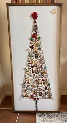 a christmas tree made out of buttons in a frame