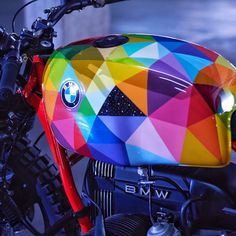 a colorful motorcycle parked on the street with it's seat up and lights on