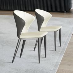 two white chairs sitting on top of a rug