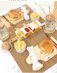 a table topped with lots of food on top of wooden trays filled with fries