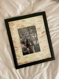 a black and white photo frame with a horse in the background on a bed sheet