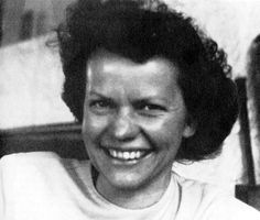 an old black and white photo of a woman smiling