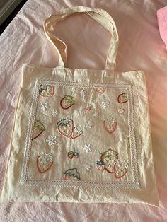 an embroidered bag sitting on top of a bed