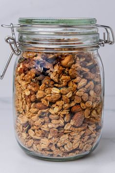 a glass jar filled with granola sitting on top of a table