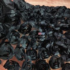 black satin rosettes are laid out on a wooden surface