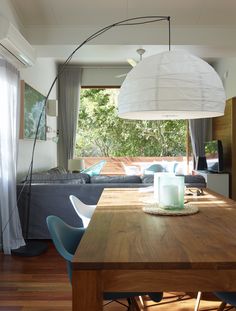 a wooden table sitting in front of a living room with blue chairs and a couch