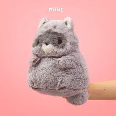 a person holding a stuffed animal in their hand with the word mini on it's forehead