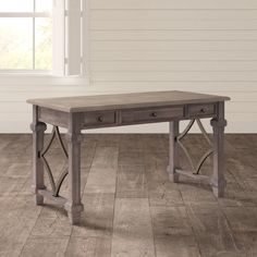 a wooden table with two drawers on it in front of a white wall and wood floor