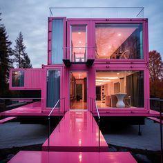 a pink house with stairs leading up to the upper floor and windows on each side