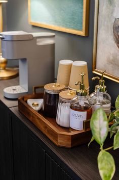 a tray with candles, soaps and other items on it next to a painting