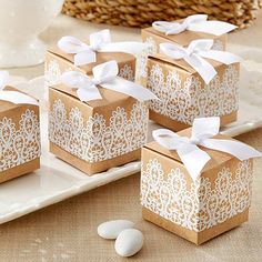 several small boxes with lace on them sitting on a table next to some coffee beans