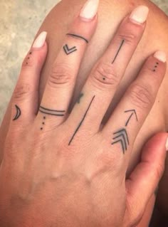 a woman's hand with two arrows tattooed on it