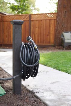 an electric cord is plugged into the ground in front of a fenced yard