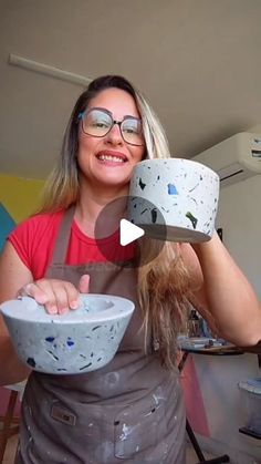 a woman in an apron is holding two bowls