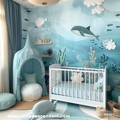 a baby's room decorated in blue and white with an underwater scene on the wall