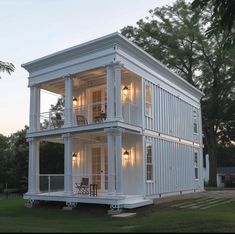 a large white house sitting on top of a lush green field