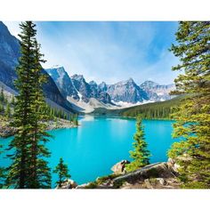 a beautiful blue lake surrounded by mountains and pine trees in the foreground, with snow capped peaks in the background