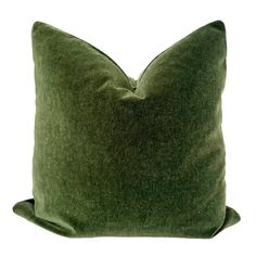 a green pillow sitting on top of a white wall