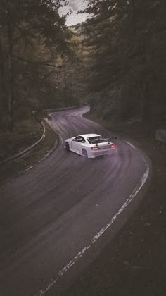 a white car driving down a winding road