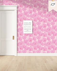 an empty room with pink flowers on the wall and a door to another room behind it