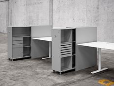 three office desks in an empty room with no one around them or on the floor