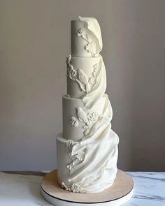 a three tiered wedding cake with white frosting