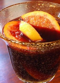 a glass filled with liquid and sliced oranges