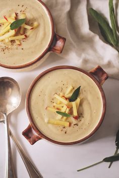 two bowls filled with soup and garnished with apples