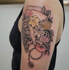 a woman's arm with flowers and a stethoscope tattoo on it