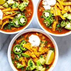 three bowls of chili soup with tortilla chips and sour cream