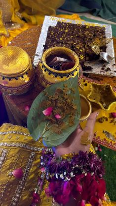 a close up of a person's face with flowers in their hair and two vases behind them