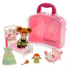 the doll is sitting in front of her pink suitcase with accessories around it and on the floor