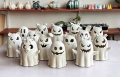 a group of halloween ghost figurines sitting on top of a table next to each other