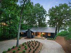 a house surrounded by trees in the woods