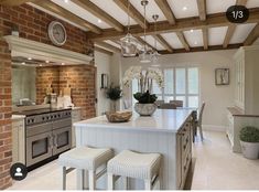 a large kitchen with an island in the middle and two stools next to it