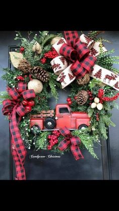 a christmas wreath with a red truck and pine cones