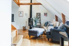 a living room filled with furniture and a fire place in the middle of a wooden floor