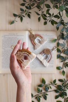 a person holding a piece of food in front of an open book on a table