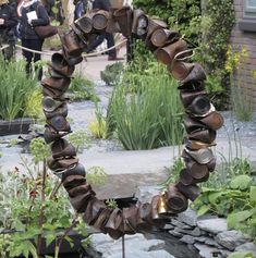 a circular sculpture made out of metal pipes in a garden