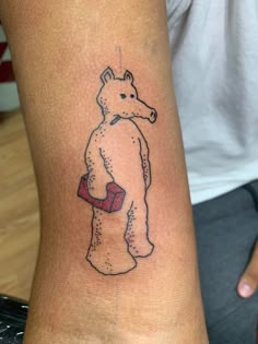 a person with a small tattoo on their arm that has a bear holding a cup