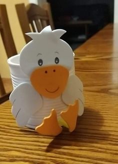 a paper duck sitting on top of a wooden table