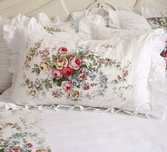 a white bed topped with lots of pillows