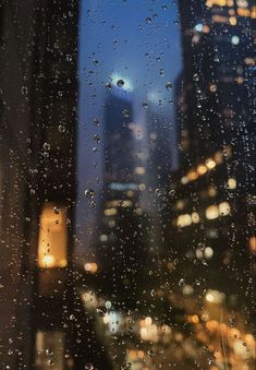 rain drops on a window with city lights in the background