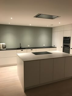 an empty kitchen with white cabinets and black counter tops