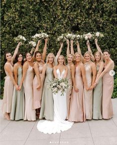 a group of women standing next to each other holding bouquets in front of them