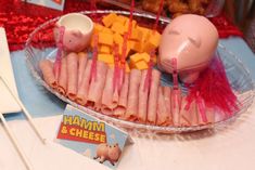 ham and cheese are arranged on a platter with toothpicks in the shape of pigs