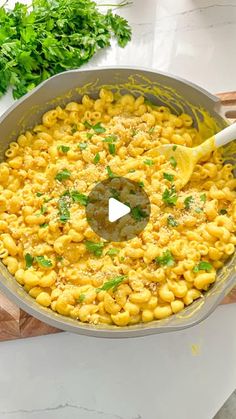 a pot filled with macaroni and cheese next to parsley