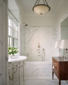 a bath room with a sink a mirror and a bath tub sitting next to a window