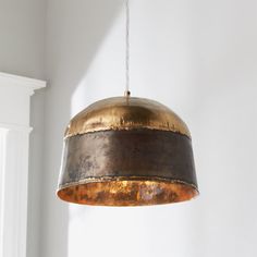 an old light hanging from a ceiling in a room with white walls and wood flooring